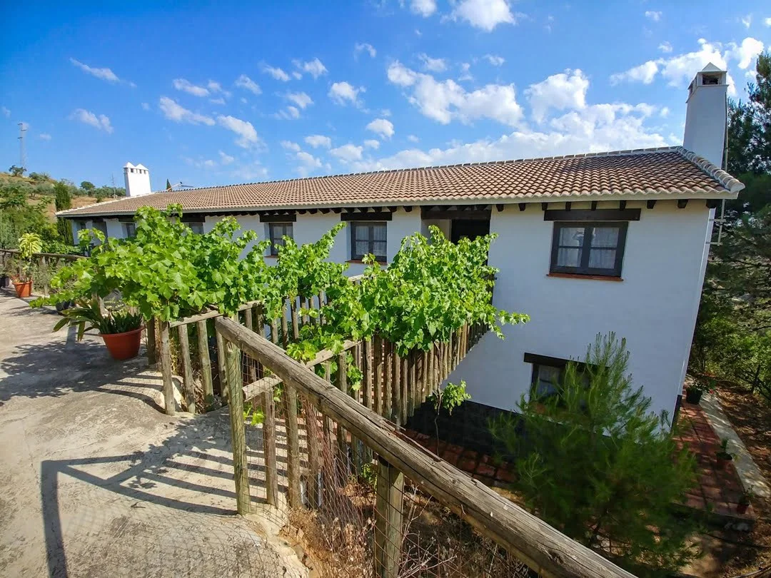 Fachada principal de finca rústica en venta en Almogía con cuatro viviendas independientes